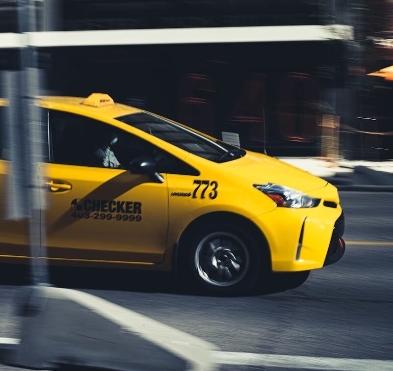 yellow taxi cab on road during daytime