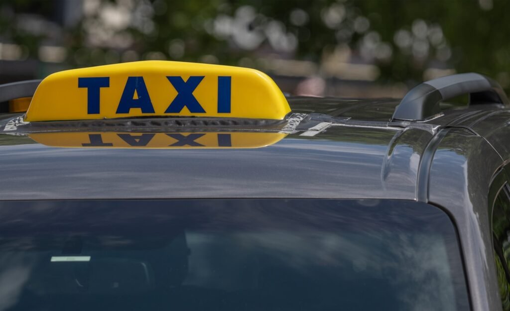 A taxi cab with a yellow taxi sign on top of it